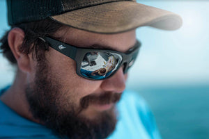 Fisherman wearing a Fin Noir sunglass while handling a fish.